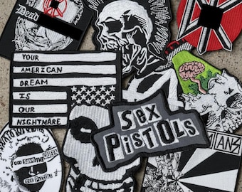May include: A collection of embroidered patches with punk rock and anti-establishment themes. Designs include a skull with a mohawk, the American flag with the text "Your American Dream Is Our Nightmare," and the words "Sex Pistols."