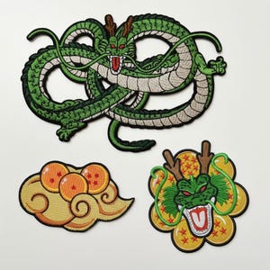 May include: Embroidered patches featuring a green dragon with a long, serpentine body, a cloud with three orange spheres, and a dragon head with a flower-like design. The patches have detailed stitching and a variety of colors.