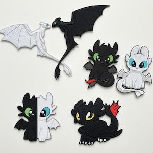 May include: A collection of embroidered dragon patches in various designs. The patches feature dragons in black and white, with green, blue, and yellow accents. Some dragons are shown in pairs, while others are single figures.