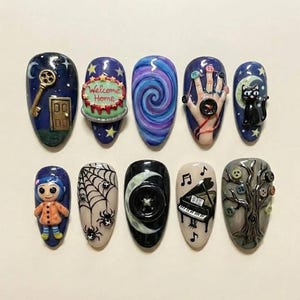 Puede incluir: Un conjunto de diez u&ntilde;as acr&iacute;licas en forma de almendra con varios dise&ntilde;os. Los dise&ntilde;os incluyen una llave y una puerta, un pastel con el texto "Welcome Home", un remolino, una mano con botones, un gato negro en una luna creciente, una mu&ntilde;eca, una telara&ntilde;a, un bot&oacute;n en una luna, un piano y un &aacute;rbol con botones.