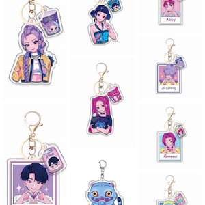 May include: A collection of acrylic keychains featuring anime-style character designs. Each keychain has a gold-colored ring and clasp. The characters are depicted in various poses and outfits, with some keychains including the character's name. The color palette includes pastels and vibrant hues.