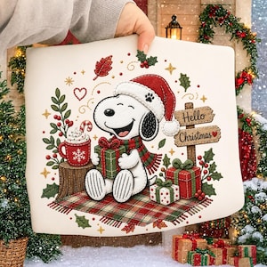 May include: A white fabric panel featuring an embroidered Snoopy wearing a red Santa hat and scarf, holding a green gift. The design includes a red mug with a candy cane, wrapped presents, holly, and a wooden sign that reads Hello Christmas.