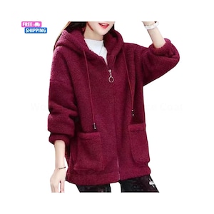 Könnte beinhalten: Burgunderfarbene Kapuzenjacke mit Reißverschluss und zwei Vordertaschen. Die Jacke hat ein weiches, strukturiertes Aussehen und eine Kapuze mit Kordelzug. Das Bild enthält auch den Text "FREE SHIPPING" in einer blauen Box.