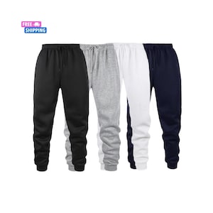 May include: Four pairs of sweatpants in black, gray, white, and navy blue. Each pair has a drawstring waist and cuffed ankles. The image includes a small graphic with the words "FREE SHIPPING".