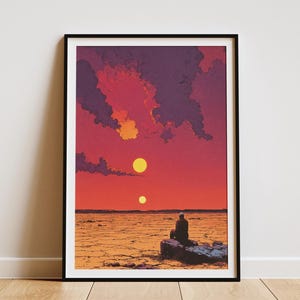 May include: Framed art print depicting a sunset scene with two suns in a vibrant orange and red sky. A figure sits on a rock in the foreground, set against a desert landscape. The artwork is framed in a black border.