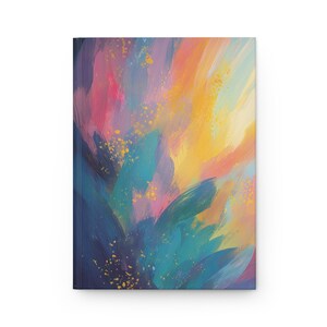 Puede incluir: Un diario de tapa dura con una pintura abstracta vibrante en la portada. La obra de arte presenta amplias pinceladas en tonos de azul, turquesa, rosa, amarillo y naranja, con pequeñas motas doradas. El diario es un lienzo en blanco para escribir y dibujar.