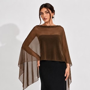 May include: A floor-length black dress featuring a strapless bodice and a sheer, dark brown, lightweight cape overlay that drapes over the shoulders and arms, creating a flowing silhouette with a straight hemline and a clean, solid finish.