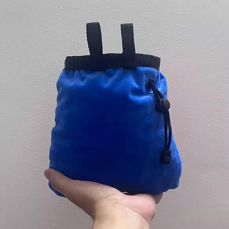 Peut inclure: Sac &agrave; magn&eacute;sie bleu pour l'escalade, avec cordon de serrage et boucles noires pour l'attache au harnais. Le sac est fait d'une mati&egrave;re douce et velout&eacute;e.