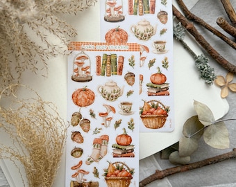 May include: Two sticker sheets featuring fall-themed illustrations. The stickers include pumpkins, mushrooms, books, teacups, acorns, and baskets of fruit. The text "LISA'S COZY STICKERS" is printed on the top of each sheet.