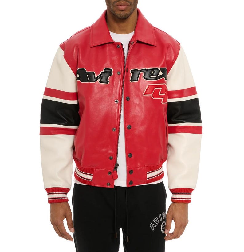 May include: Red leather jacket with white sleeves and black accents. The jacket features the text "Avi Rex" in black lettering on the chest and a number "4". The jacket has a button-up front and ribbed cuffs.
