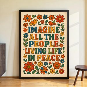 Puede incluir: Una impresión artística enmarcada con un borde negro. La obra de arte presenta las palabras "IMAGINE ALL THE PEOPLE LIVING LIFE IN PEACE" en letras coloridas de estilo retro. El diseño incluye flores naranjas, azules y amarillas, hojas verdes y dos pájaros naranjas.