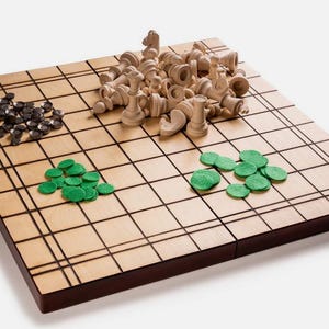 Könnte beinhalten: Ein Holzbrettspiel mit einer hellbraunen Oberfläche und dunkelbraunen Kanten. Das Brett ist in Quadrate mit schwarzen Linien unterteilt. Auf dem Brett verstreut sind hellfarbige Schachfiguren, schwarze Spielsteine und grüne runde Spielsteine.