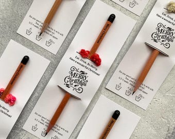 Puede incluir: Una colección de lápices con cápsulas de semillas adjuntas, presentados en tarjetas blancas. Cada lápiz está impreso con "Merry Christmas". Las tarjetas también presentan el texto "Eat, Drink, Be Merry. Have a wonderful Christmas!" e instrucciones de plantación.