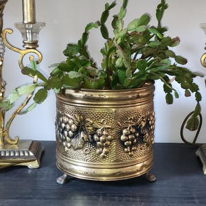 Vaso da fiori vintage in ottone lombardo con piedini a forma di artiglio, decorato con uva in rilievo, stile Hollywood Regency di metà secolo
