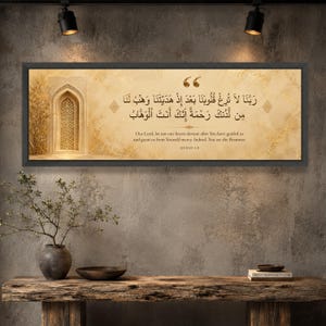 May include: A rectangular wall art piece in a black frame featuring a beige background with gold accents. It displays an illustration of an arched doorway and Arabic calligraphy with the English translation: Our Lord, let not our hearts deviate.