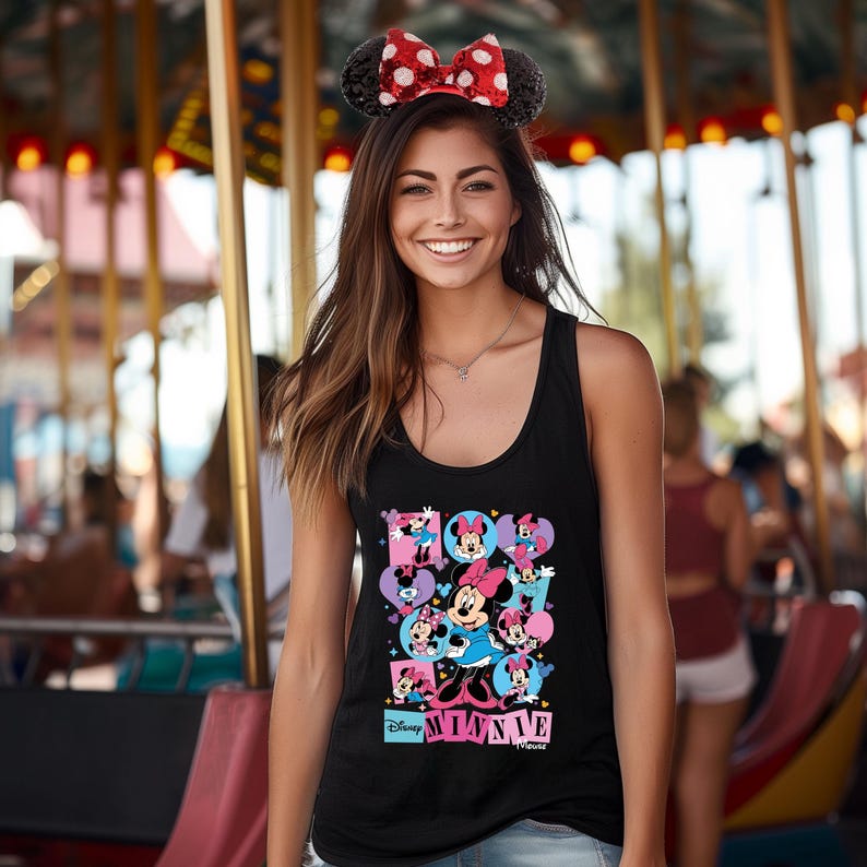 May include: Black tank top featuring a colorful graphic of Minnie Mouse in various poses. The design includes the text "Disney Minnie Mouse" in a playful font. The model is wearing a Minnie Mouse ear headband with a red bow.