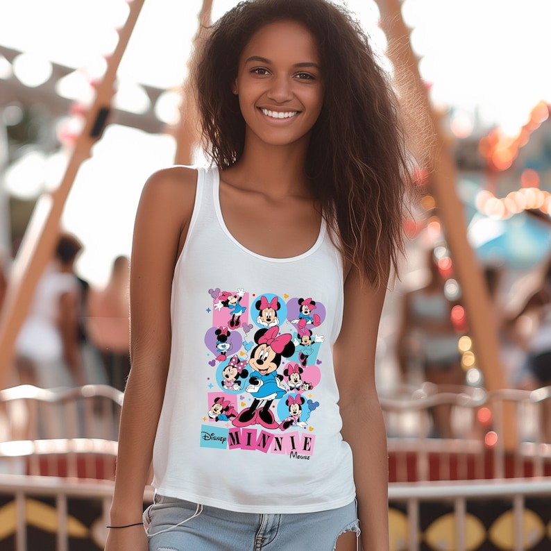 May include: White tank top featuring a colorful graphic of Minnie Mouse in various poses. The design includes the text "Disney Minnie Mouse" in a playful font, with pink, blue, and purple accents. The tank top is sleeveless.