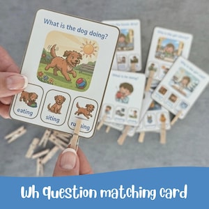 Op de afbeelding: Educatieve matchingkaarten met de tekst "Wat doet de hond?" tonen illustraties van een hond die speelt, eet, zit en rent. De kaarten worden vastgehouden met houten wasknijpers.