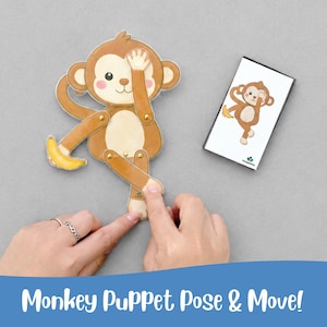 May include: A brown monkey puppet with a yellow banana, and a matching card. The puppet has movable limbs and is positioned with one hand over its eye. The card shows the same monkey pose. The text "Monkey Puppet Pose & Move!" is at the bottom.