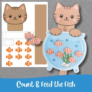 Puede incluir: Un set de actividades imprimible titulado Count & Feed the Fish que incluye una cabeza de gato marrón, una pecera azul con algas verdes y varios recortes de peces payaso naranjas y blancos para contar y jugar.