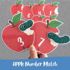 Peut inclure: Un ensemble de découpes plastifiées en forme de pommes rouges avec des feuilles vertes, des chiffres blancs et un petit ver vert. Chaque pomme présente un détail de morsure. Le lot comprend plusieurs pommes avec des chiffres imprimés.