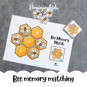 Puede incluir: Un juego de memoria con temática de abejas en una tarjeta blanca. El juego presenta formas de panal amarillas con ilustraciones de abejas. Se muestra el texto "Bee Memory Match", junto con el nombre de la marca "Brainjoykids".