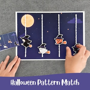 Könnte beinhalten: Ein Halloween-Mustersuchspiel mit einem dunkelblauen Nachthimmel-Hintergrund, einem gelben Mond, violetten Wolken und Sternen. Vier vertikale, weiße, strukturierte Kordeln halten bewegliche Ausschnitte einer Hexe, eines Geistes, eines Kürbisses und einer schwarzen Katze.