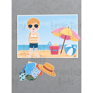 Peut inclure: Un ensemble de poup&eacute;e en papier repr&eacute;sentant un personnage de dessin anim&eacute; sur une plage avec un parasol jaune et rose, un seau rouge et un ballon de plage bleu et blanc. Sous la sc&egrave;ne se trouvent divers v&ecirc;tements en papier, dont des shorts et un chapeau de paille.