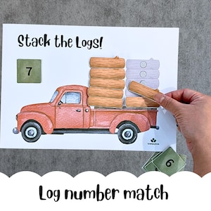May include: A children's educational game with a red truck illustration and wooden log pieces. The text "Stack the Logs!" is at the top, and "Log number match" is at the bottom. A hand is placing a log on the truck.