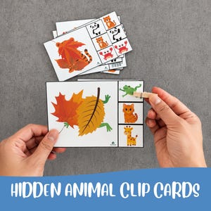 Peut inclure: Un ensemble de cartes rectangulaires blanches illustrant des animaux partiellement cachés derrière des feuilles d'automne colorées. Chaque carte comporte un panneau latéral avec trois options d'animaux à identifier. Une pince en bois marque le choix.