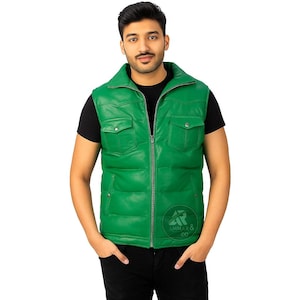 Puede incluir: Un chaleco de cuero verde brillante con diseño acolchado, dos bolsillos delanteros y cierre de cremallera. El chaleco tiene cuello alto y un logotipo en la parte inferior derecha. La persona lleva una camiseta negra.