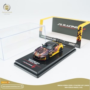 Może przedstawiać: Szczegółowy model samochodu Honda S2000 J's Racing (AP1) MAOU w skali 1:64. Samochód ma czarny dach, żółte i fioletowe akcenty oraz skomplikowaną grafikę. Stoi na czarnej podstawie ekspozycyjnej z logo "JS RACING".