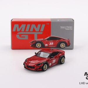May include: A red diecast model car of a Nissan Z Pandem, with the number 23 on the side. The model is in front of its box, which has the Mini GT logo and a picture of the car. The text "722" is visible.