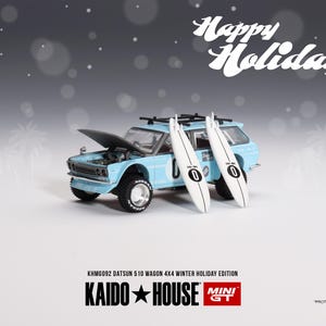 Könnte beinhalten: Hellblaues Datsun 510 Kombi-Modell mit geöffneter Motorhaube, gepaart mit zwei weißen Surfbrettern. Die Surfbretter haben die Nummer "0". Im Hintergrund steht der Text "Happy Holidays!"
