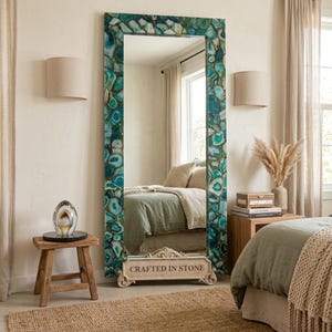 May include: A tall rectangular floor mirror featuring a frame composed of numerous polished teal and blue agate stone slices. At the base of the mirror, a decorative stone plaque is engraved with the text CRAFTED IN STONE in capital letters.