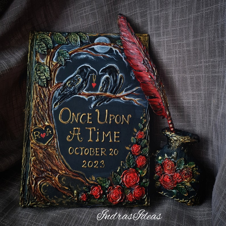 May include: Black and gold wedding guest book with a tree, two ravens, and red roses. The book says "Once Upon A Time" and "October 20, 2023".