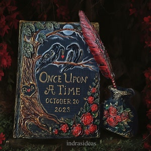 May include: A black and gold wedding invitation with a dark background and red roses. The invitation features two black ravens and the text "Once Upon A Time" with the date "October 20, 2023".