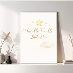 Puede incluir: Impresión enmarcada con la frase "Twinkle Twinkle Little Star" en escritura elegante. El diseño presenta estrellas doradas y una nube sobre un fondo blanco, ideal para una habitación infantil.