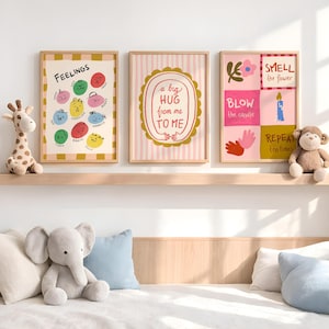 May include: Three framed art prints with text and illustrations. One print says "FEELINGS" with colorful faces. Another says "a big HUG from me TO ME". The third says "SMELL the flower, BLOW the candle, REPEAT ten times".