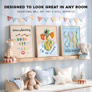 May include: Three framed prints with educational themes, including "Sensory Grounding" and "Mindful Snakes." The prints are displayed on a wooden shelf, with plush toys and decorative pillows. A banner of colourful flags hangs above.