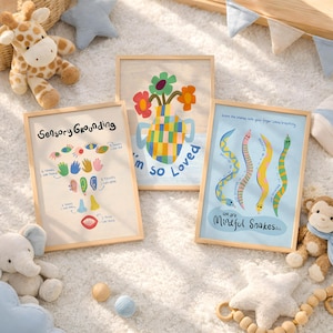May include: Three framed art prints with light wood frames. One print says "Sensory Grounding" with colourful illustrations. Another says "I'm so Loved" with a vase of flowers. The third says "We are Mindful Snakes" with snake illustrations.