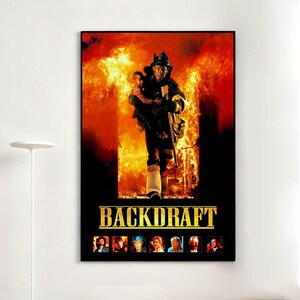 Peut inclure: Affiche encadrée du film "Backdraft". L'affiche montre un pompier portant un enfant hors d'un bâtiment en feu. L'arrière-plan est rempli de flammes, et le titre est en lettres dorées.