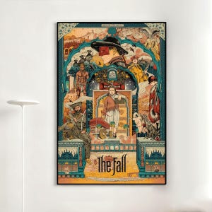 Puede incluir: Una impresión artística enmarcada con una ilustración colorida y estilizada. Presenta una figura central con sombrero y gafas rojas. La obra incluye figuras, elementos arquitectónicos y el texto "The Fall" en la parte inferior, sobre un fondo turquesa y amarillo.