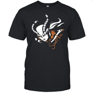 Peut inclure: T-shirt noir avec une illustration stylisée d'un personnage aux cheveux blancs et un motif cuivré. Le texte "Sand Man" est écrit en script cuivré sur le t-shirt.