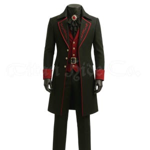 Puede incluir: Abrigo largo negro con ribetes y detalles rojos, combinado con un chaleco rojo y pantalones negros. El abrigo presenta costuras rojas decorativas en las solapas y puños. Una camisa negra con volantes y una broche enjoyada completan el conjunto. El atuendo se exhibe en un maniquí.