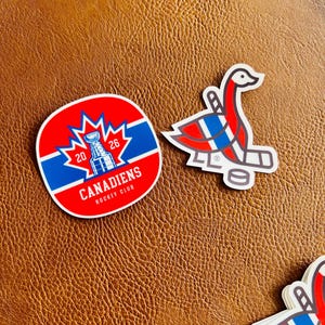 May include: A selection of stickers showcasing the Montreal Canadiens hockey team. One sticker is a circular emblem with the team name and a Stanley Cup graphic. Another sticker depicts a stylized goose with hockey sticks and a puck.