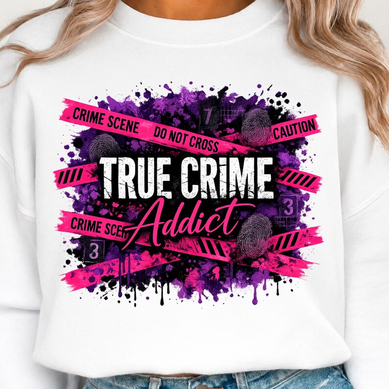 May include: A white sweatshirt featuring a graphic print with purple and black paint splatters. The design includes pink crime scene tape with the text "CRIME SCENE DO NOT CROSS CAUTION," fingerprint icons, and the words "TRUE CRIME Addict" in white.