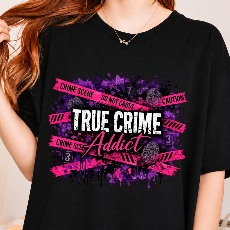 May include: A black t-shirt featuring a graphic design with purple and pink paint splatters, pink crime scene tape with the text CRIME SCENE DO NOT CROSS CAUTION, fingerprint icons, evidence markers labeled 3 and 7, and the text TRUE CRIME Addict.