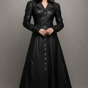 May include: A long, black leather coat with a button-down front, a belted waist, and a wide collar. The coat features decorative studs on the shoulders and sleeves. The coat is floor-length and has a flared skirt.