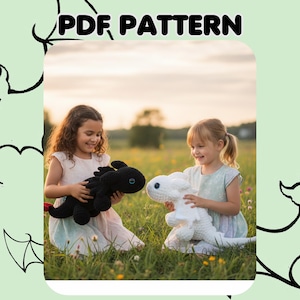 May include: Two children in a field holding crocheted dragon toys. One dragon is black with a red tail, the other is white. The text "PDF PATTERN" is at the top of the image. The children are smiling.